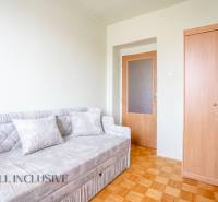 A room with a sofa, a wooden wardrobe, and a floor in a family house.