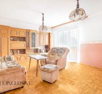 Living room with comfortable seating, a coffee table, and a wooden wall unit in a family house.