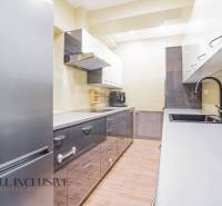 Spacious kitchen in a family house with glossy cabinets and modern appliances.