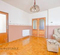 Wooden doors, wall-mounted radiators, and a patterned sofa in a family house.