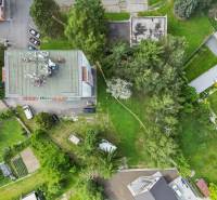 Aerial view of plots - housing on Slnečná Street in Kováčová, surrounded by greenery and cars.