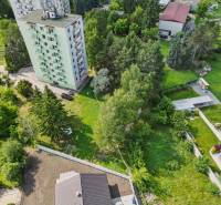 Apartment building surrounded by greenery on Slnečná Street in Kováčová, residential plots.