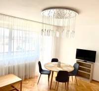 Living room in a two-room apartment with a round table, armchairs, and a television.