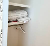 Storage space with folded clothes and hangers in a 2-room apartment.