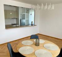 Dining table with four chairs, kitchen with a counter window in a 2-room apartment.