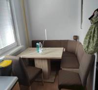 Dining area with a sofa and table in a 3-room apartment, minimalist furnishings.