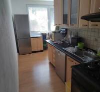 A kitchen in a 3-room apartment with a bright interior and wooden cabinets.