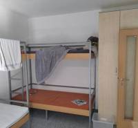 Bunk bed and wardrobes in a 3-room apartment with simple furnishings.