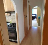 A hallway with entrances to the kitchen and a room in a 3-room apartment.