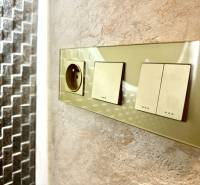 Sockets and switches on a stone wall in a 3-room apartment.