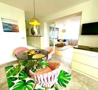 Dining area with a round table, chairs, and a television in a 3-room apartment.