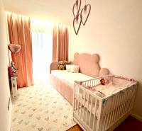 Children's room in a 3-room apartment with pink details and wooden flooring.