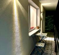 Balcony of a 3-room apartment with decorative tiles and wall lighting.