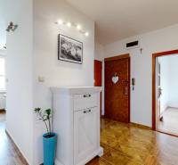 A hallway in a 3-room apartment with white furniture and wooden floors.