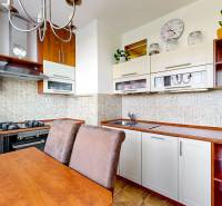 Kitchen in a 3-room apartment with a dining table, gas stove, and microwave.