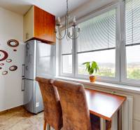 A kitchen in a 3-room apartment with circular decoration, a table, and a view from a large window.