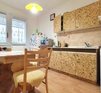 A kitchen in a 3-room apartment with wooden furniture and patterned cabinets.