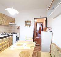 A kitchen in a 3-room apartment with a dining table and a gas stove.