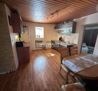 Wooden interior of the kitchen with a dining table and kitchen unit in a family house.