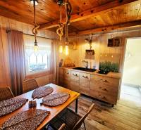 Interior of a cottage with wooden furniture, kitchen unit, and decorative elements.