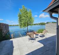 Terrace by the lake in Čaňa near the cottage with two chairs and a table.