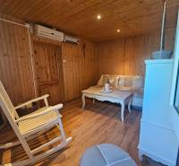 Wooden interior with air conditioning, rocking chair, and sofa in the cabin.