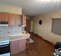 A kitchen with a wooden cabinet and a stove in a 3-room apartment.