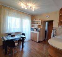 Dining table with chairs in the kitchen of a 3-room apartment, wooden floor.