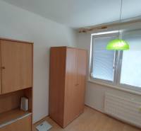 Interior of a 3-room apartment with a wooden wardrobe and a green hanging lamp.