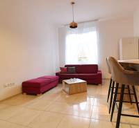 Living room with a red sofa and bar stools in a 3-room apartment.