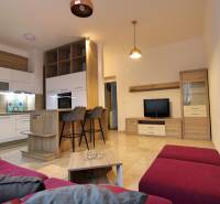 Living room with kitchen and dining area in a 3-room apartment with a purple sofa.