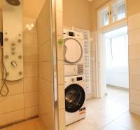 Bathroom with a washing machine, shower corner, and radiator in a 3-room apartment.
