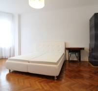 A bright room with an antique tiled stove and a white bed in a 3-room apartment.