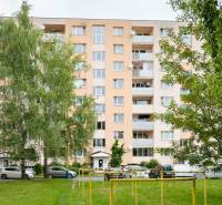 An apartment building on Prostějovská Street in Prešov surrounded by greenery with a parking lot.