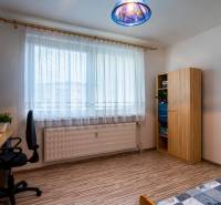 A bright room with a desk, chair, wardrobe, and bed in a 3-room apartment.