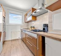A kitchen with wooden cabinets and appliances in a 3-room apartment, bright and spacious.