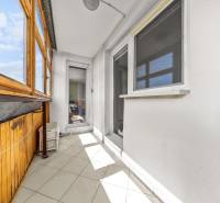 Glazed balcony with white walls and wooden paneling, 3-room apartment.