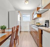 A kitchen in a 3-room apartment with a dining table and wooden accessories.