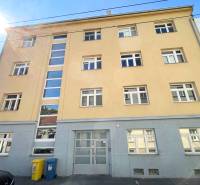 Building on Cintorínska Street in Bratislava – Old Town with parking and waste containers.