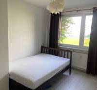 Bright bedroom with a bed and a large window in a 3-room apartment.