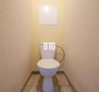 A bathroom in a one-room apartment with tiled flooring and light-colored walls.