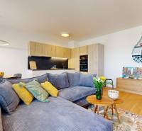 A spacious living area in a 2-room apartment with a comfortable sofa and a kitchenette.