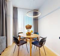 A dimly lit dining room with a round table and chairs in a 2-room apartment.