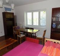 Living room in a family house with a library, sofa, and dining table.