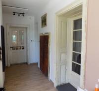A hallway in a family house with a wooden floor and old doors.