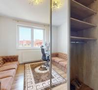 A room with light walls, a carpet, a brown sofa, and a desk in a 4-room apartment.
