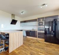 A kitchen with built-in appliances and bar stools in a 4-room apartment.