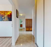 A hallway in a 4-room apartment with tiles and a picture of Buddha on the wall.