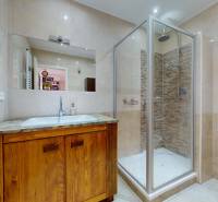 A bathroom with a shower and a wooden cabinet in a 4-room apartment.