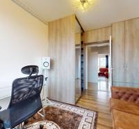 Office in a 4-room apartment with an office chair, sofa, and wooden cabinet.